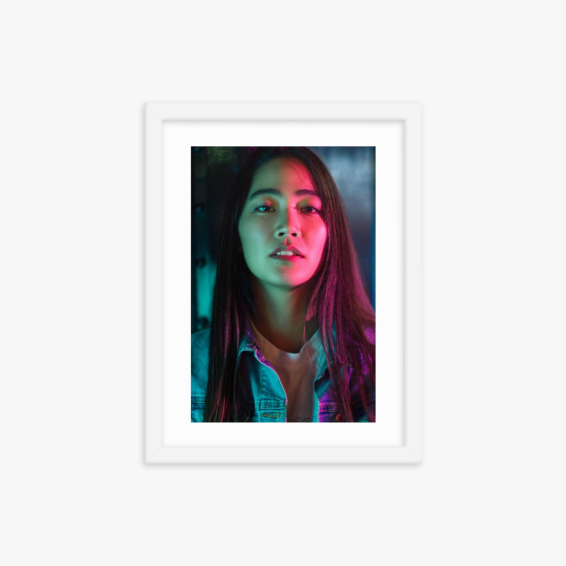 Portrait of young woman lit by colorful neon lights at night 12x16 in Poster With White Frame